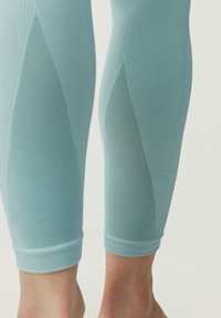 Světle modré sportovní legíny s žebrovanou strukturou, s síťovinovými panely a těsným střihem do půli lýtek, s pohodlným pasem v horní části.