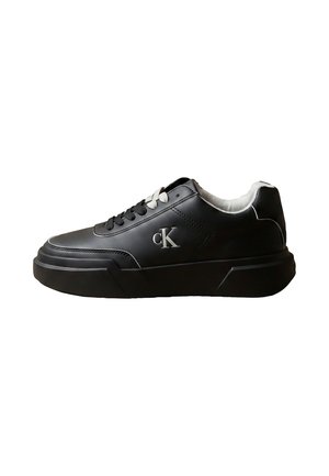 Czarny niski sneaker z białym wnętrzem, czarno-białymi sznurowadłami, grubą podeszwą i logo "cK" po boku.