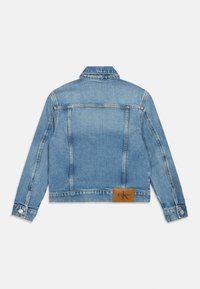 Heled sinise denim jakk klassikalise disainiga, millel on terav krae, nööbiga mansetid ja nahast logopaat tagaküljel.