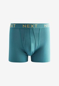Tipe boxeralsó arany "NEXT" logóval a derékrészen, sima szövettextúrával és testhezálló kialakítással.