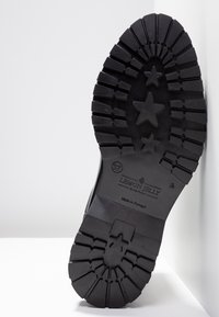 Suela de goma negra con un patrón de textura y estrellas. Presenta el nombre de la marca en relieve "LEMON JELLY" y la talla "37." Fabricado en Portugal.