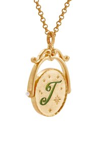 Gouden hanger ketting met een ovale vorm, vergezeld van een groene "J", kleine parelaccenten en sterrenpatronen op een gestructureerd oppervlak.