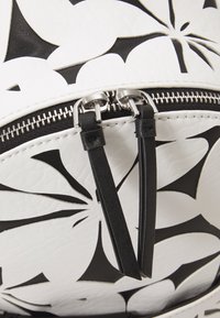 Schwarzer und weißer, floral gemusterter Rucksack aus strukturiertem Kunstleder, mit einem doppelten Reißverschluss mit schwarzen Ledergriffen und silbernen Hardware-Akzenten.