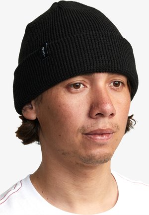 Schwarze gerippte Strickmütze mit umgeschlagenem Saum und einem kleinen Markenetikett. Die Textur scheint weich und flexibel zu sein und sitzt eng am Kopf.