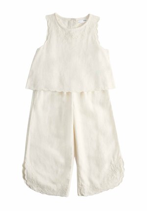 Top crema senza maniche e pantaloni a gamba larga con bordi smerlati e delicati ricami floreali sulle spalle e sull'orlo dei pantaloni.