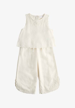Top crema senza maniche e pantaloni a gamba larga con bordi smerlati e delicati ricami floreali sulle spalle e sull'orlo dei pantaloni.