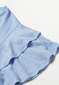 Lyseblåt, tekstureret stof med en bølget kant. Designet har et blødt, let materiale, der er velegnet til afslappet brug.