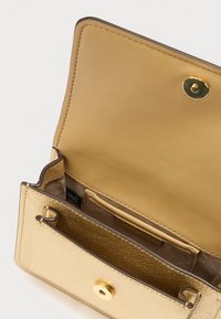 Geantă din piele aurie cu exterior texturat, interior neted, compartiment central și închidere circulară cu magnet.