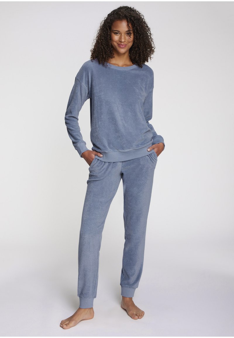 Soft blue loungewear set made of textured fabric. The top features a loose fit with ribbed cuffs, while the pants have an elastic waist and banded hems.