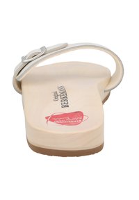 Beige wooden clogs with a single adjustable strap. Textured insole with branding; a rubber sole provides traction.