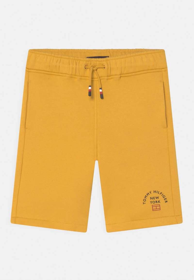 Short jaune à taille élastique avec cordon, poches latérales et logo Tommy Hilfiger New York sur la partie inférieure de la jambe gauche.