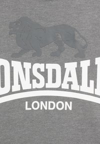 Siva pamučna majica s tamnosivim grafičkim prikazom lava i bijelim tekstom "Lonsdale London" ispisanim podebljanim fontom.