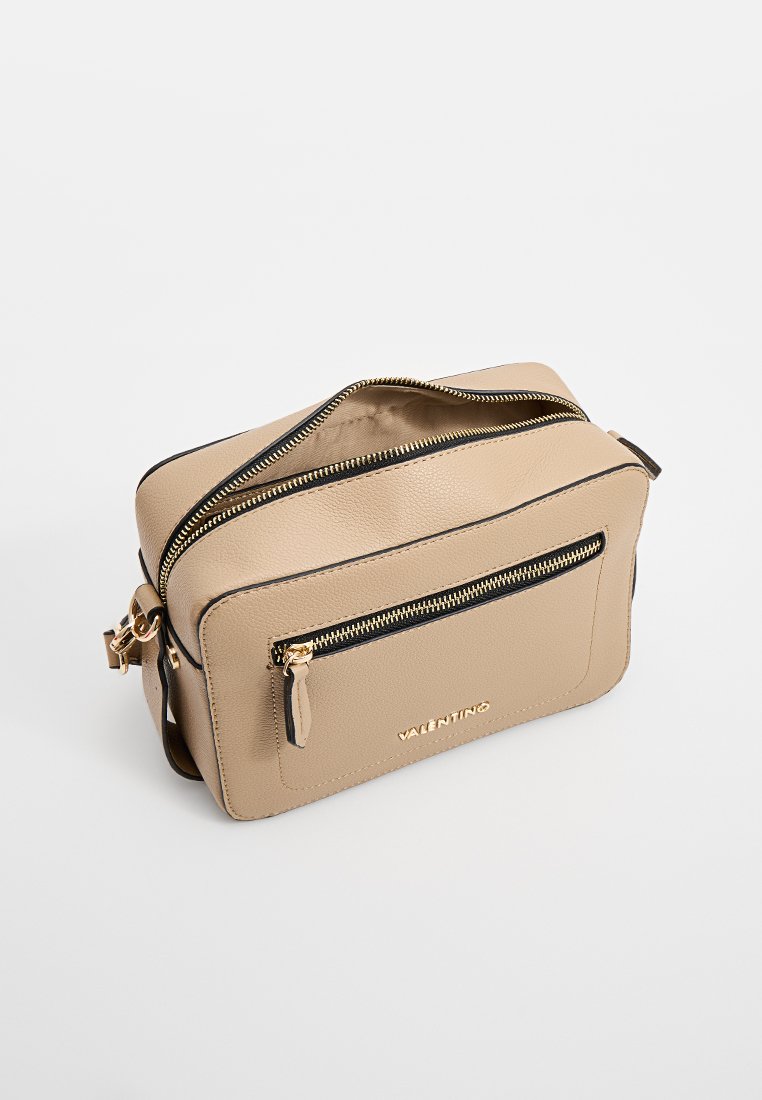 Beige Handtasche aus Leder mit strukturiertem Finish, vergoldeten Beschlägen, Reißverschluss oben und einer vorderen Reißverschlusstasche mit Logo-Detail.