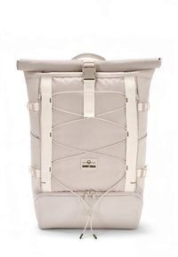 Mochila beige con cierre enrollable, correas ajustables, parche con logo en el frente, hebillas laterales y acabado de tela texturizada. Cuenta con cierre de cordón.