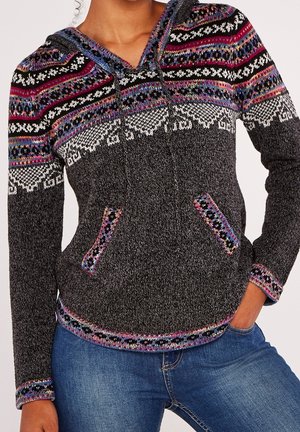 Sweat à capuche en maille gris foncé avec des motifs nordiques multicolores sur le yoke, les poignets et les poches, porté avec un jean bleu.