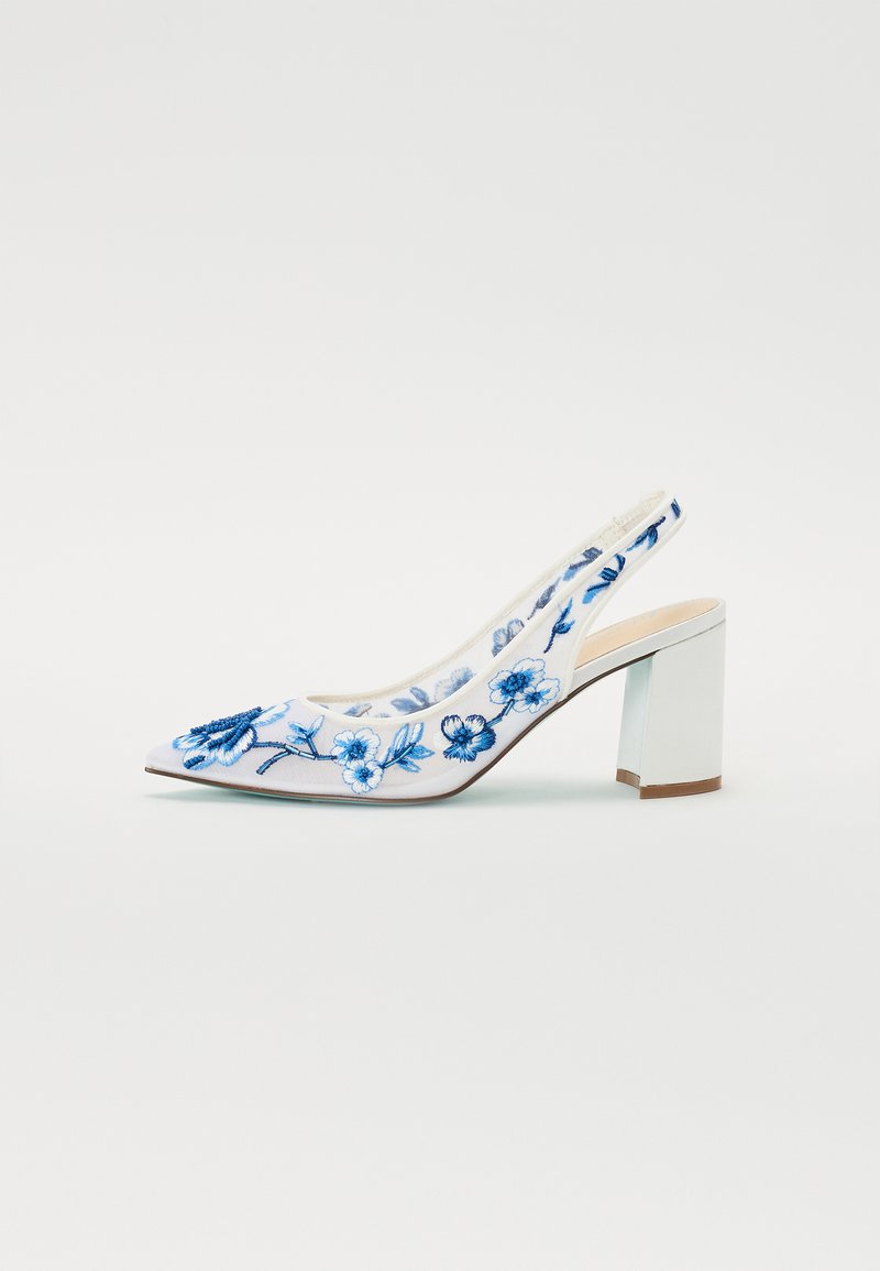 Fehér slingback magassarkú, kék virágmintás hímzéssel, hegyes orral és négyzetes blokksarkakkal. Simább textúra, bonyolult részletezéssel.