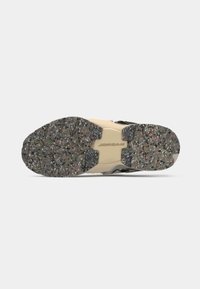 Η εξωτερική σόλα του αθλητικού παπουτσιού διαθέτει υφή γκρι καουτσούκ με πολύχρωμες βούλες, εξέχον ενδιάμεσο πέλμα σε ανοιχτό μπεζ και λογότυπο «JORDAN».