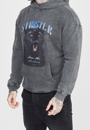 Graue Kapuzenjacke mit einem großen schwarzen Panther-Print, känguru-artiger Fronttasche und gerippten Bündchen. Das Material wirkt weich mit einer abgetragenen Textur.