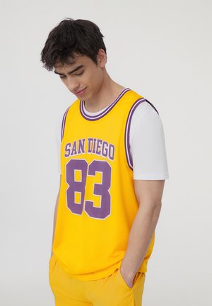 Canotta da basket in rete gialla con accenti bianchi e viola, che presenta in modo prominente la scritta "SAN DIEGO" e il numero "83".