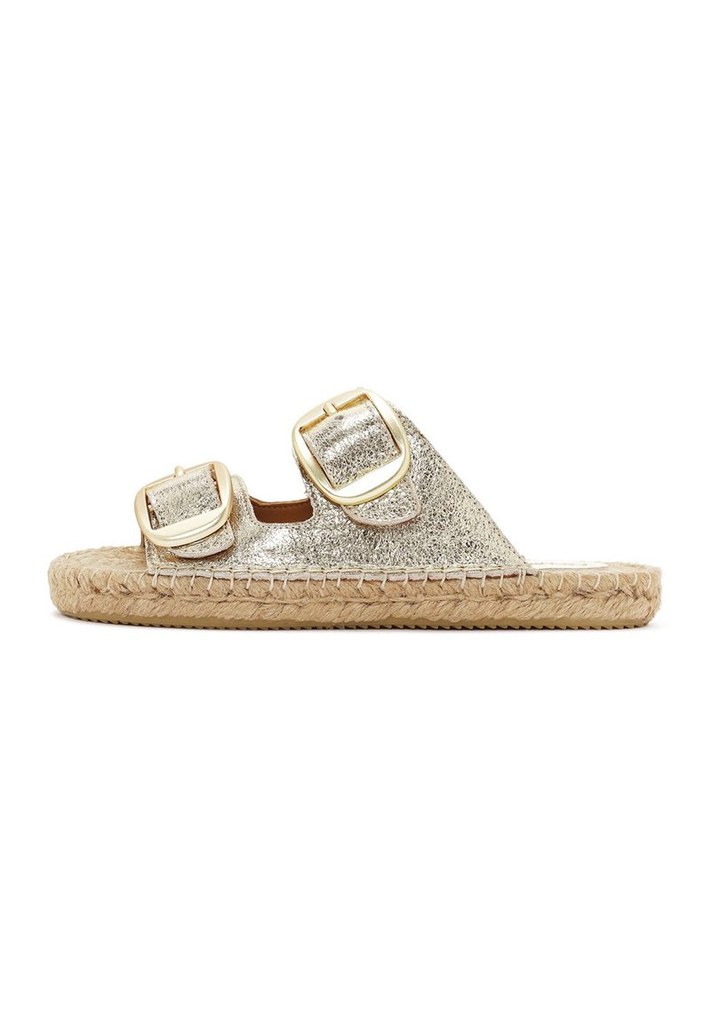 Gouden metalen espadrille-slippers met twee oversized gespen, een geweven jute zool en een vlak profiel. Gladde textuur met een glanzende afwerking.