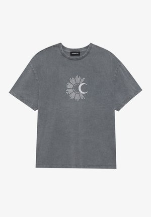 T-shirt en coton gris à manches courtes, texture irrégulière, avec un graphique de rayons de soleil et d'une lune croissante en blanc au centre.
