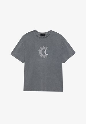 Grå bomull t-skjorte med korte ermer, uregelmessig tekstur, og et grafisk design av solstråler og en halvmåne i hvitt midt på.