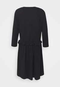 Svart klänning i mjukt tyg, med långa ärmar och rynkad midja. Sömmen är något utsvängd för en avslappnad passform.