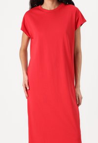 Rotes, kurzärmliges Kleid in knielanger Länge mit rundem Ausschnitt, aus glattem, elastischem Stoff für Komfort und Bewegungsfreiheit.