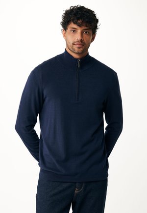 Maglione pullover blu navy con colletto alto e mezza zip. Texture a maglia, maniche lunghe e design aderente. Adatto per un abbigliamento casual.