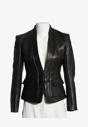 Blazer negro de cuero ajustado con hombros estructurados, bolsillos con solapa y un escote en V profundo en un torso de maniquí blanco.