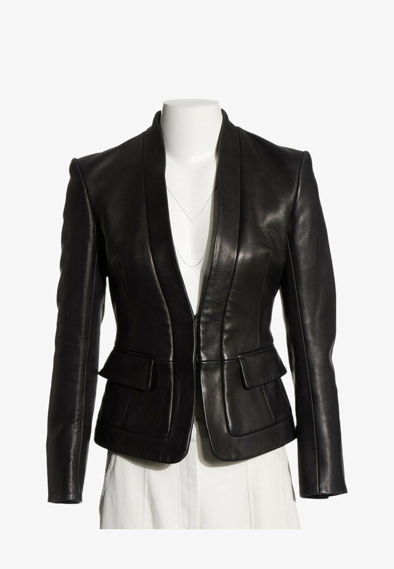 Blazer en cuir noir ajusté avec épaules structurées, poches à rabat et un profond décolleté en V sur un buste de mannequin blanc.