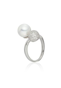 Anillo de plata con una gran perla blanca y un acento esférico texturizado cubierto de pequeñas piedras preciosas transparentes. Acabado suave y pulido.