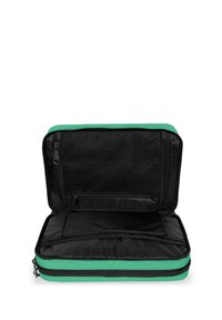 Černá a zelená zipová taška s síťovanou kapsou, která má měkkou texturu, obdélníkový tvar a otevřenou vnitřní přihrádku.