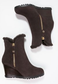 Kilklackade ankelstövlar i mörkbrun mocka med fuskpälskant, med dragkedja i sidan och diamantmönstrad quiltad ovandel. Texturerad svart sula.