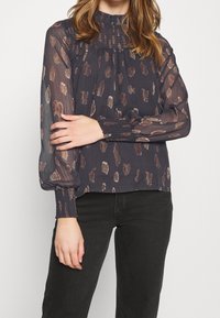 Blusa blu scuro con vestibilità ampia, caratterizzata da un motivo testurizzato in crema e malva, maniche lunghe trasparenti e polsini smock.