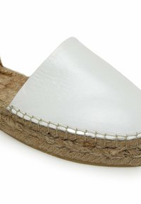 Espadrille en cuir blanc avec semelle en jute naturel et couture visible le long du bord sur fond blanc.