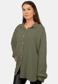 Over-sized olijfgroene shirt van gestructureerde katoen, met een knoopsluiting aan de voorkant, een omklapbare kraag en lange mouwen.