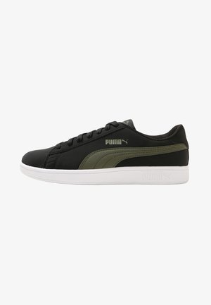 Zapatillas sintéticas negras con detalles en verde oliva, suela de goma blanca, punta redonda y diseño con cordones que presenta el logotipo de Puma en el lateral.