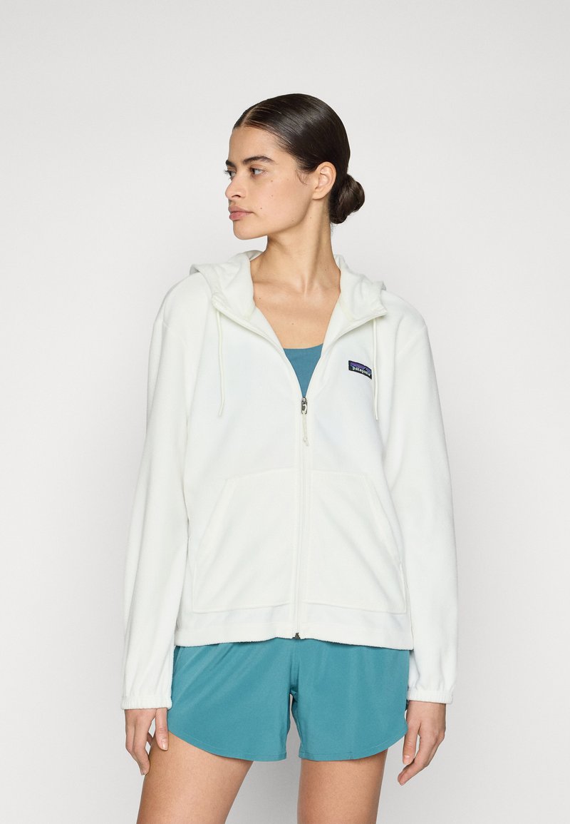 Crème rits-hals hoodie gemaakt van zachte fleece met een gestructureerde afwerking, voorzien van een capuchon met trekkoord en voorzakken. Gepaard met teal shorts.