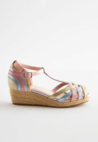 Højhælet sandal med en vævet jutesål. Overdelen har korsremme i pastelfarver: guld, pink, blå og lavendel. Justerbar ankelsnor.