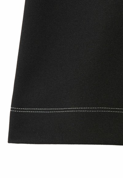 Tessuto nero con superficie testurizzata, caratterizzato da una cucitura bianca lungo l'orlo. Il design è semplice con una finitura a taglio dritto.