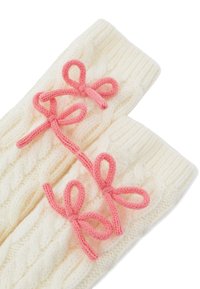Guantes de punto en color crema con un patrón de trenzas; presenta tres acentos de moño rosa en la parte delantera. Textura suave, ajuste ceñido y diseño acogedor.