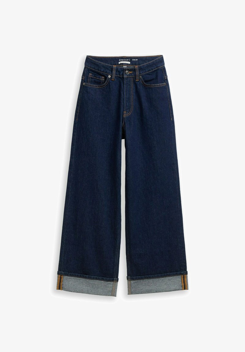 Tummat farkut leveillä lahkeilla, joissa on käänteet ja näkyvää oranssia tikkausta, sekä klassinen viisi-taskuinen muotoilu.