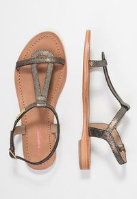 Vlakke sandalen met metallic bronzen banden, een bruine leren voetbed, en een minimalistisch ontwerp met een kleine hak en een verstelbare enkelband.