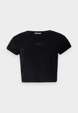 Čierny rebrovaný krátky rukáv crop top vyrobený z mäkkého materiálu, s jemným logom Calvin Klein v strede. Jednoduchý, klasický dizajn.