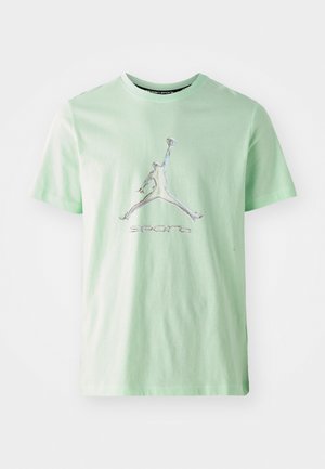T-shirt in cotone verde menta con collo a giro. Presenta un logo Jumpman riflettente e il testo "sports" sotto il logo. Texture liscia.