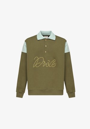 Sudadera verde oliva con cuello azul claro, con la palabra "Drôle" bordada en dorado y tres botones dorados en la tapeta. Tejido de mezcla de algodón.