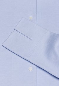 Lichtblauw lange mouwen shirt van een gestructureerde stof, met oprollbare manchetten, knoopsluiting en een nette afwerking van de naden.