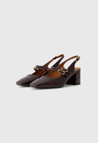 Brown patent leather slingback heels with a square toe, two adjustable straps, and a block heel design. Smooth texture and polished finish.