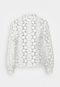 Blouse blanche en dentelle à manches longues avec motif floral, col montant et poignets boutonnés, présentée sur un fond uni.